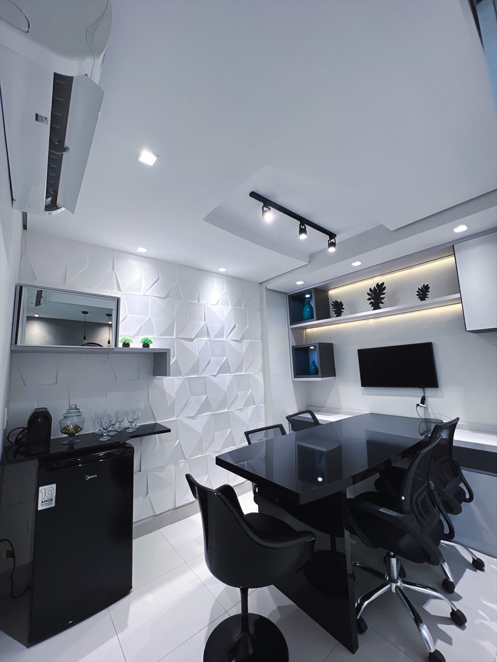 Sala de reunião da CooWorks com TV e climatização